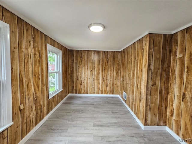 11 Bryant St, Utica, NY 13502 - unfurnished room with wood walls, light wood-type flooring, and baseboards