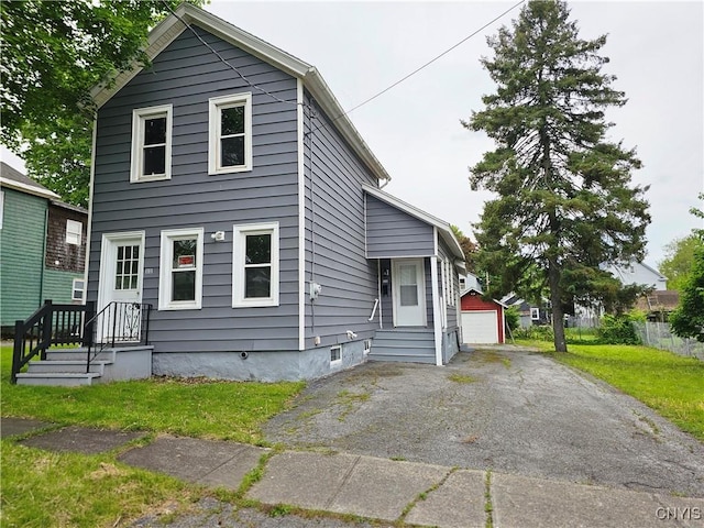 11 Bryant St, Utica, NY 13502 - view of front of property with an outdoor structure, a detached garage, asphalt driveway, and a front yard