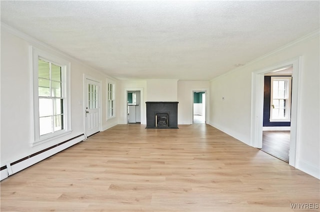 5002 Armor Duells Rd, Orchard Park, NY 14127 - unfurnished living room with crown molding, a baseboard heating unit, light wood-type flooring, a brick fireplace, and a textured ceiling