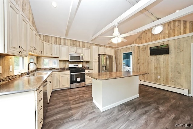 5002 Armor Duells Rd, Orchard Park, NY 14127 - kitchen featuring appliances with stainless steel finishes, a sink, a baseboard radiator, wooden walls, and a center island