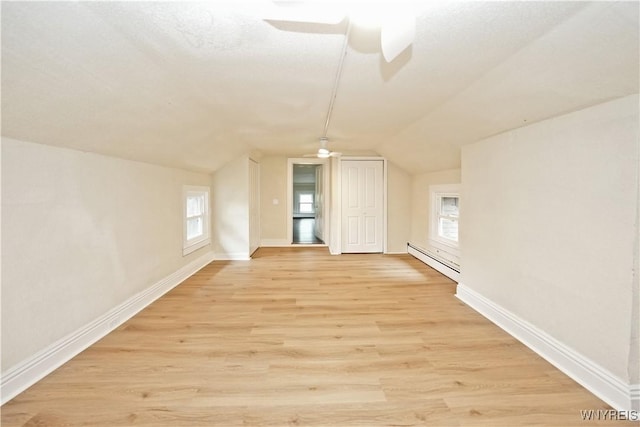 5002 Armor Duells Rd, Orchard Park, NY 14127 - additional living space with a ceiling fan, vaulted ceiling, a baseboard heating unit, light wood finished floors, and baseboards