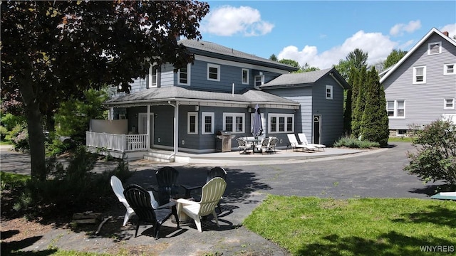 34 Maple St, Ellery, NY 14712 - rear view of property featuring a porch, an outdoor fire pit, and a patio area