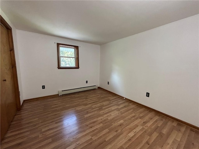 606 County Highway 12, Laurens, NY 13796 - unfurnished bedroom featuring a baseboard radiator, wood finished floors, and baseboards