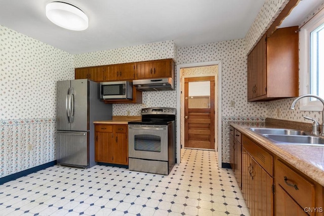 299 Sharp Rd, Granby, NY 13069 - kitchen featuring appliances with stainless steel finishes, wallpapered walls, a sink, under cabinet range hood, and light floors