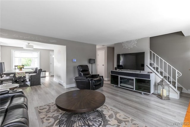 195 Robert Dr, North Tonawanda, NY 14120 - living area featuring stairs, light wood-style floors, baseboards, and a chandelier
