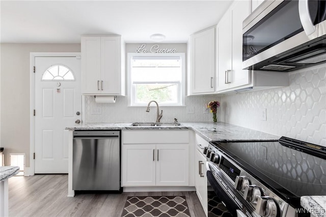 195 Robert Dr, North Tonawanda, NY 14120 - kitchen with stainless steel appliances, a sink, light stone countertops, and light wood-style flooring