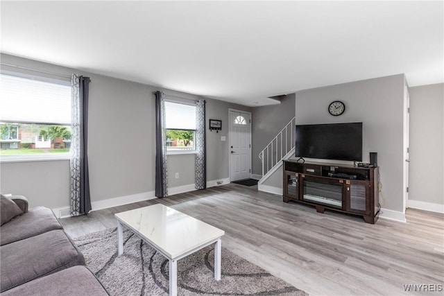 195 Robert Dr, North Tonawanda, NY 14120 - living room with stairs, light wood finished floors, and baseboards