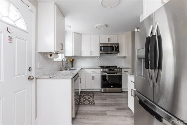 195 Robert Dr, North Tonawanda, NY 14120 - kitchen with appliances with stainless steel finishes, a sink, white cabinetry, and decorative backsplash