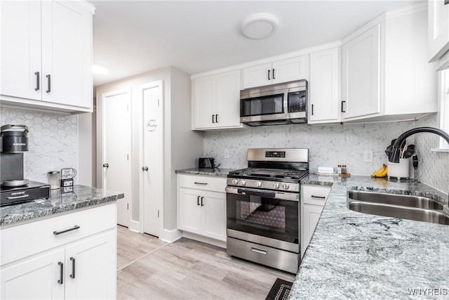 195 Robert Dr, North Tonawanda, NY 14120 - kitchen with stainless steel appliances, a sink, decorative backsplash, and light wood-type flooring