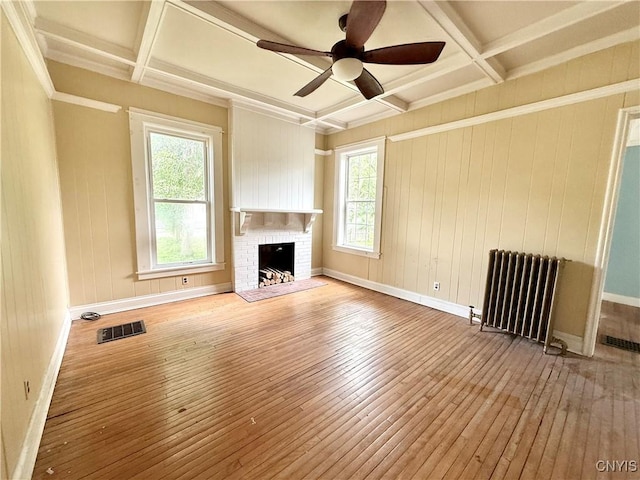 140 Maple St, Le Ray, NY 13612 - unfurnished living room with radiator heating unit, hardwood / wood-style flooring, coffered ceiling, baseboards, and beam ceiling