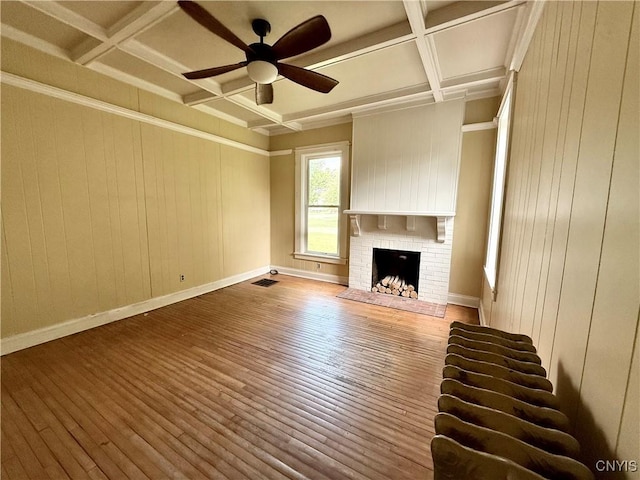 140 Maple St, Le Ray, NY 13612 - unfurnished living room with coffered ceiling, hardwood / wood-style flooring, ceiling fan, beam ceiling, and a fireplace