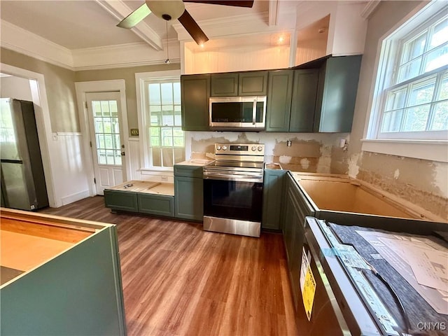 140 Maple St, Le Ray, NY 13612 - kitchen featuring appliances with stainless steel finishes, wood finished floors, ceiling fan, crown molding, and green cabinetry