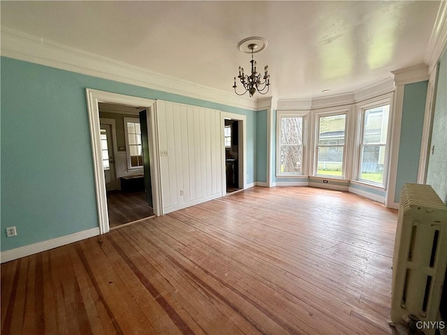 140 Maple St, Le Ray, NY 13612 - unfurnished room with radiator, a chandelier, ornamental molding, wood-type flooring, and baseboards