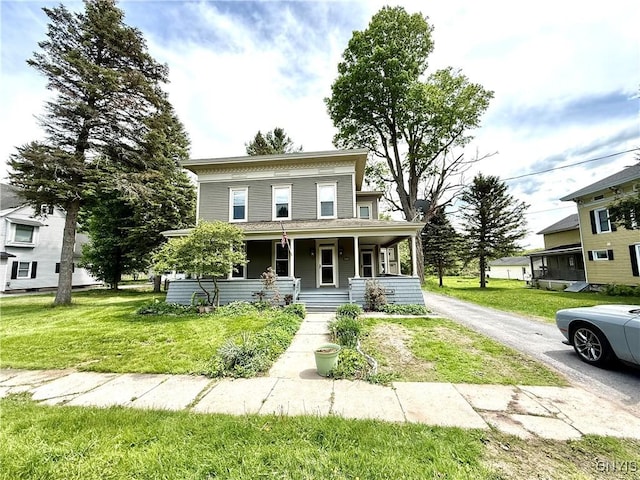 140 Maple St, Le Ray, NY 13612 - italianate home featuring a porch, a front yard, and asphalt driveway