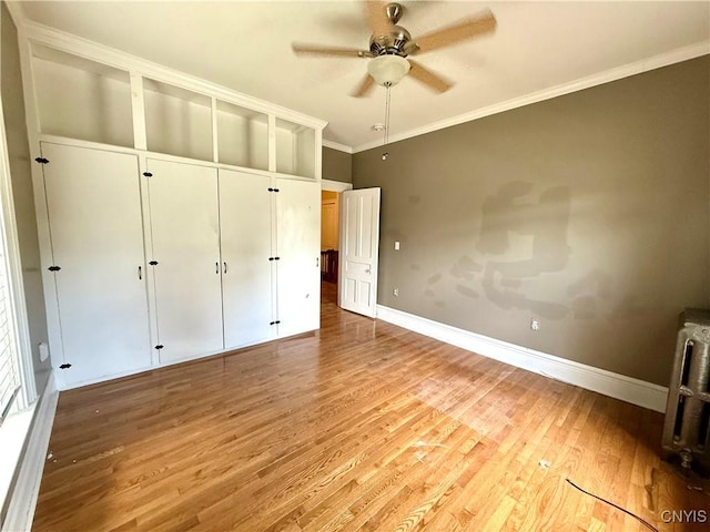 140 Maple St, Le Ray, NY 13612 - unfurnished bedroom with wood finished floors, radiator, baseboards, crown molding, and a ceiling fan