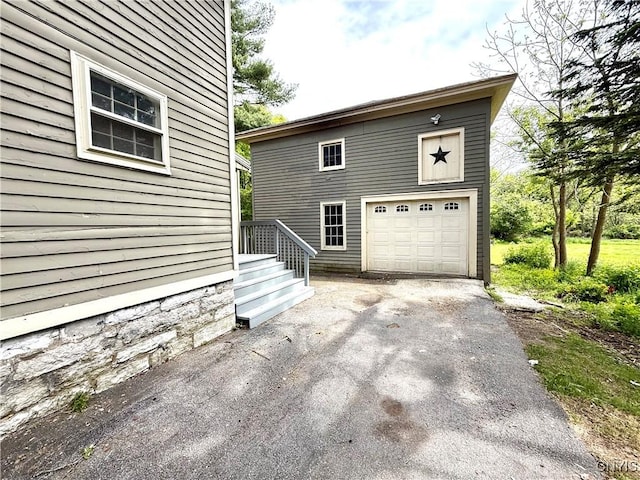 140 Maple St, Le Ray, NY 13612 - view of side of property featuring asphalt driveway and a garage