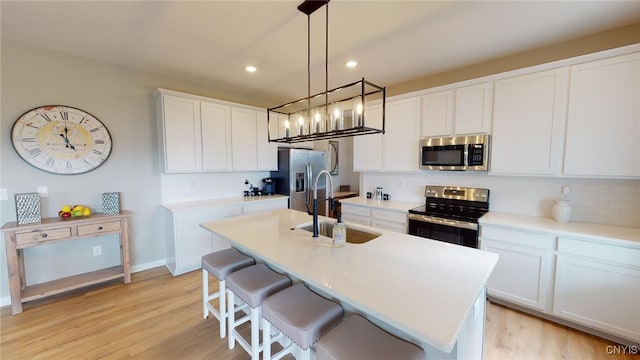 213 Lexi Ln, Van Buren, NY 13027 - kitchen featuring appliances with stainless steel finishes, a sink, recessed lighting, an island with sink, and a kitchen bar