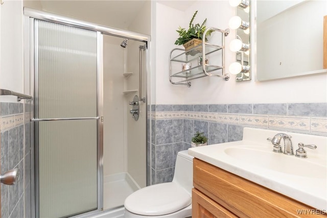 24 Glenbourne Ct, Amherst, NY 14221 - bathroom with vanity, tile walls, a stall shower, toilet, and a wainscoted wall