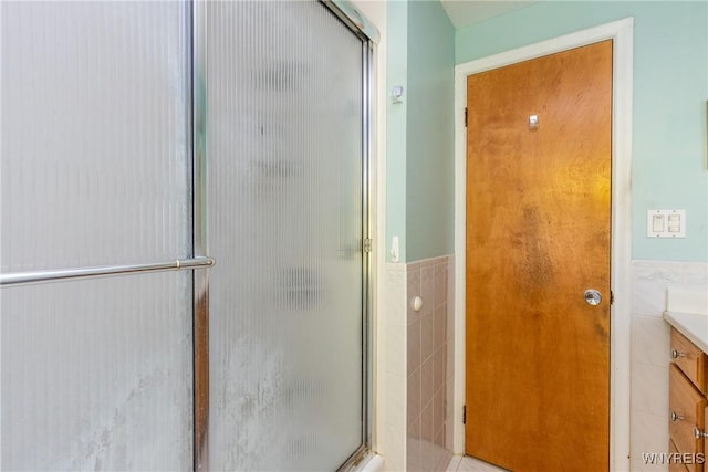 24 Glenbourne Ct, Amherst, NY 14221 - full bathroom featuring vanity, a shower stall, tile walls, and a wainscoted wall