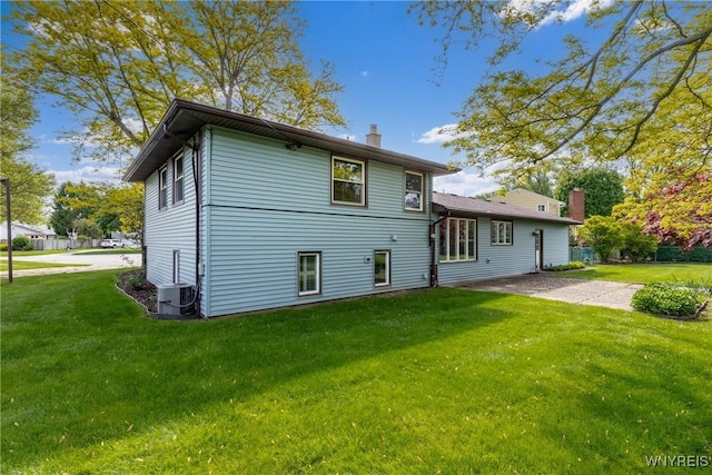 24 Glenbourne Ct, Amherst, NY 14221 - back of house featuring a chimney, a yard, and central AC unit
