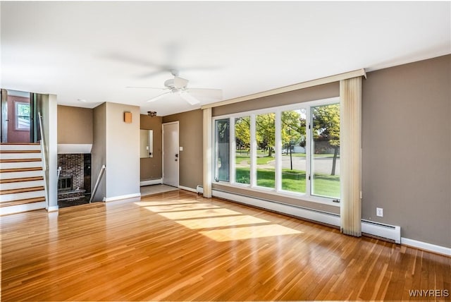 24 Glenbourne Ct, Amherst, NY 14221 - unfurnished living room featuring a baseboard radiator, wood finished floors, baseboards, and ceiling fan