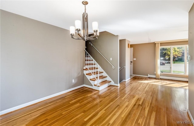 24 Glenbourne Ct, Amherst, NY 14221 - spare room with a baseboard heating unit, a chandelier, stairway, light wood-style flooring, and baseboards