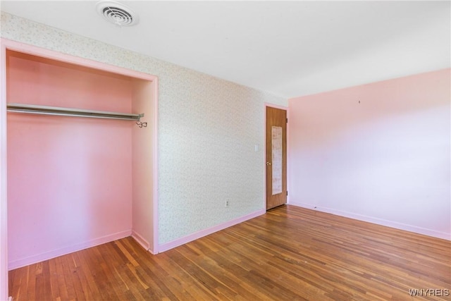 24 Glenbourne Ct, Amherst, NY 14221 - unfurnished bedroom with wood finished floors, baseboards, and a closet