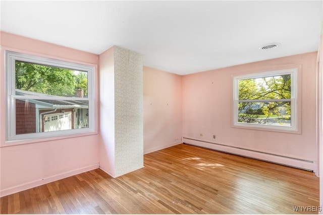 24 Glenbourne Ct, Amherst, NY 14221 - unfurnished room with baseboard heating, wood finished floors, and baseboards