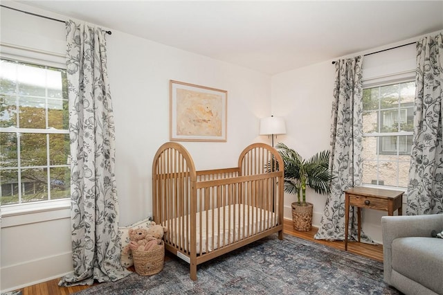 196 Elmcroft Rd, Rochester, NY 14609 - bedroom featuring wood finished floors, a crib, and baseboards