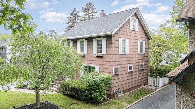 196 Elmcroft Rd, Rochester, NY 14609 - view of home's exterior featuring roof with shingles and a chimney