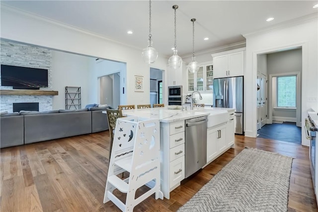 101 Coventry Rdg, Pittsford, NY 14534 - kitchen with appliances with stainless steel finishes, ornamental molding, open floor plan, glass insert cabinets, and white cabinets