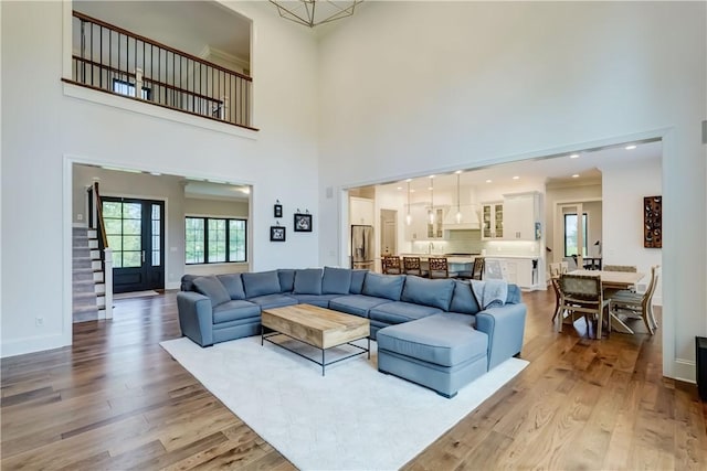 101 Coventry Rdg, Pittsford, NY 14534 - living area featuring a towering ceiling, light wood finished floors, baseboards, and stairway
