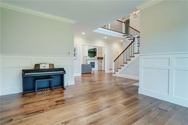 101 Coventry Rdg, Pittsford, NY 14534 - entrance foyer featuring a decorative wall, stairs, ornamental molding, a stone fireplace, and wood finished floors