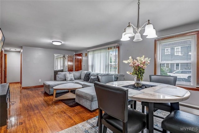 892 Northland Ave, Buffalo, NY 14215 - dining area featuring a chandelier, healthy amount of natural light, wood finished floors, and baseboards