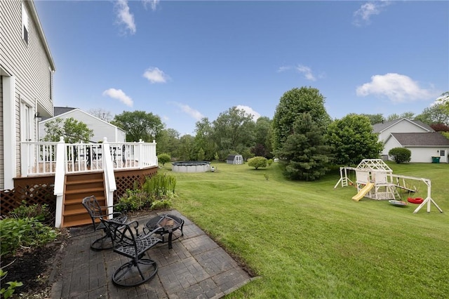 717 Westwood Trl, Walworth, NY 14502 - view of green lawn with an outdoor fire pit, a patio area, a playground, a deck, and stairway