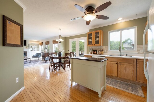 717 Westwood Trl, Walworth, NY 14502 - kitchen with a sink, ornamental molding, brown cabinets, a kitchen island, and a ceiling fan
