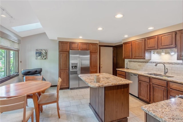 8807 Wandering Way, Lysander, NY 13027 - kitchen featuring appliances with stainless steel finishes, a sink, a skylight, a kitchen island, and tasteful backsplash