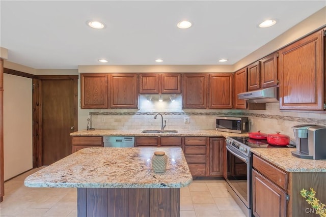 8807 Wandering Way, Lysander, NY 13027 - kitchen with a sink, stainless steel appliances, under cabinet range hood, light stone countertops, and tasteful backsplash