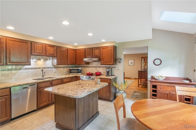 8807 Wandering Way, Lysander, NY 13027 - kitchen with stainless steel appliances, a sink, under cabinet range hood, backsplash, and light stone countertops