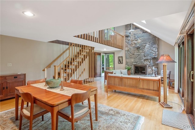 8807 Wandering Way, Lysander, NY 13027 - dining space with light wood finished floors, stairs, a stone fireplace, and lofted ceiling