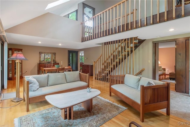 8807 Wandering Way, Lysander, NY 13027 - living area with a high ceiling, stairs, a skylight, plenty of natural light, and wood finished floors