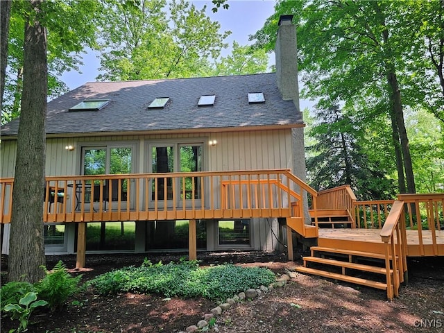 8807 Wandering Way, Lysander, NY 13027 - rear view of house featuring a shingled roof, a wooden deck, stairs, and a chimney