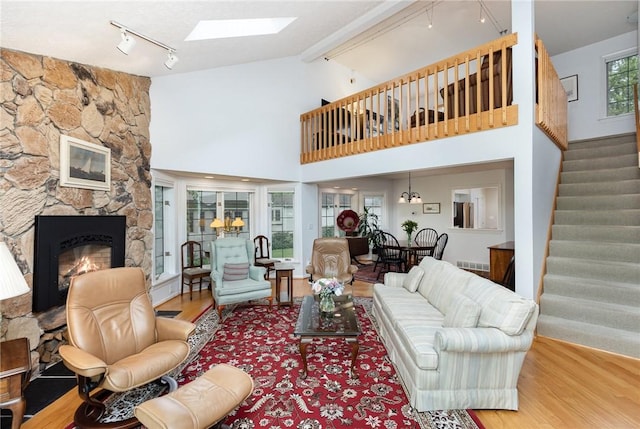 716 Mariner Cir, Webster, NY 14580 - living area featuring rail lighting, wood finished floors, stairs, a fireplace, and a skylight
