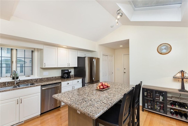 716 Mariner Cir, Webster, NY 14580 - kitchen featuring stainless steel appliances, a sink, lofted ceiling, stone counters, and white cabinetry