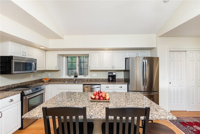 716 Mariner Cir, Webster, NY 14580 - kitchen featuring appliances with stainless steel finishes, a sink, a breakfast bar area, and light stone countertops