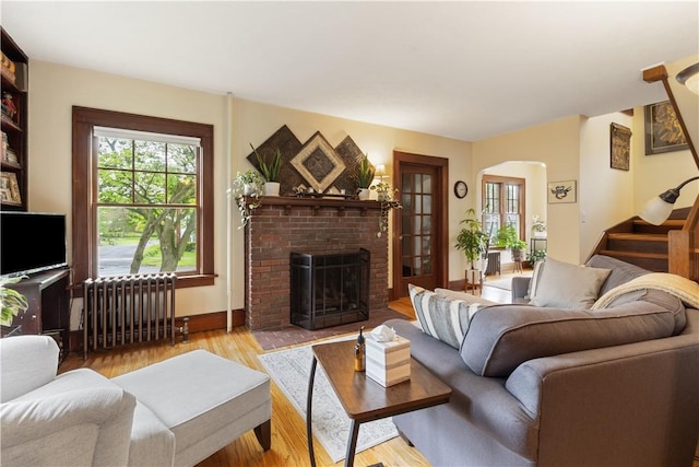 456 N Main St, Benton, NY 14527 - living room featuring radiator, healthy amount of natural light, wood finished floors, and stairs