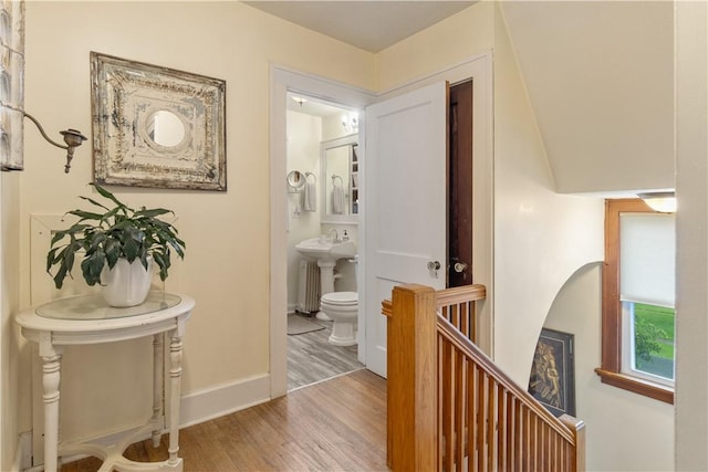 456 N Main St, Benton, NY 14527 - hallway featuring wood finished floors, baseboards, a sink, and an upstairs landing