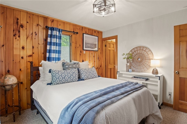 6525 Bonnie Castle Rd, Huron, NY 14590 - bedroom featuring light colored carpet, wood walls, a chandelier, and baseboards