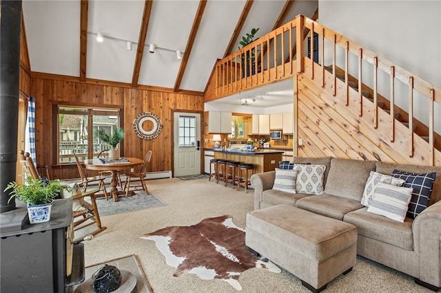 6525 Bonnie Castle Rd, Huron, NY 14590 - living room with high vaulted ceiling, healthy amount of natural light, wood walls, beamed ceiling, and light carpet