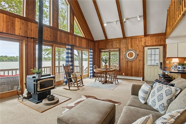 6525 Bonnie Castle Rd, Huron, NY 14590 - living room with a wood stove, a baseboard radiator, high vaulted ceiling, beam ceiling, and light carpet